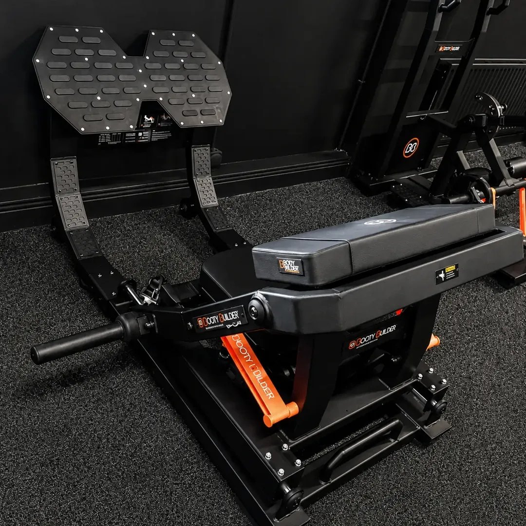 A plate-loaded hip thrust machine on the gym floor
